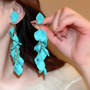 Detailed close-up of teal rose petal tassel earrings on a model showing elegant drape