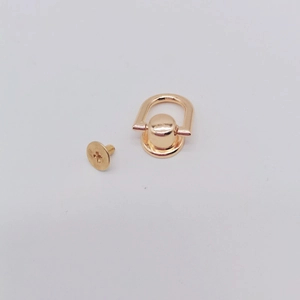 Primer plano de anilla en D metálica dorada con tornillo para bolsos DIY y fundas móvil