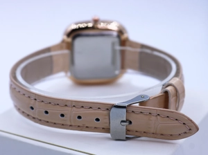 Macro view of pink leather strap with crocodile texture and silver buckle on square watch