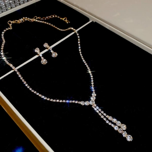 Detail of elegant gold-toned necklace and earring set with crystals in a velvet gift box
