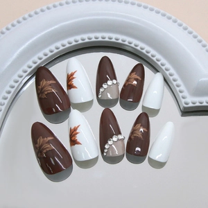 Faux ongles amande avec feuilles d'érable, strass étincelants en marron et blanc