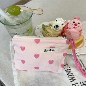 Close-up of pink heart print canvas mini bag with zipper and woven strap detail