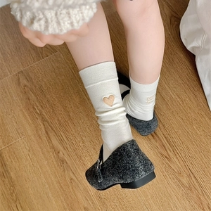 Detail of cream white mid-calf cotton socks with heart and text embroidery on the model