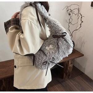 Detail of grey faux fur shoulder bag featuring a leather bow and silver butterfly clasp