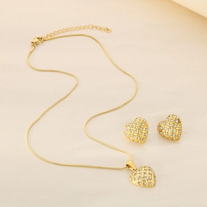 Detailed shot of golden heart-shaped woven jewelry set with sparkling white rhinestones