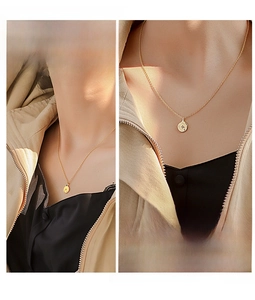 Detail shot of a minimalist gold coin necklace with engraved star motif worn by a model