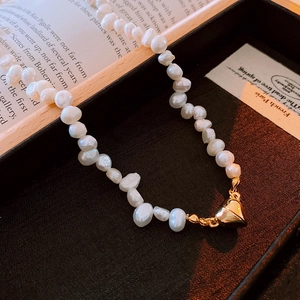 Baroque freshwater pearl necklace with gold heart magnetic clasp on elegant display