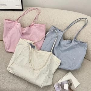 Detail of glitter star patterns on soft pink, blue, and beige canvas tote bags with lining