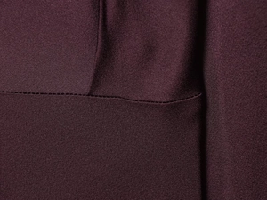 Nahaufnahme der dunkelvioletten Satinstruktur mit professionellen industriellen Nähten