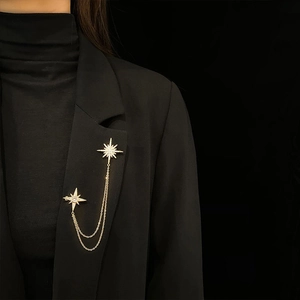 Elegant gold hexagram chain brooch with sparkling zircons on a black blazer