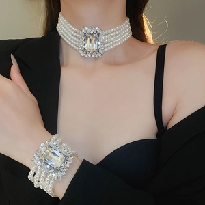 Luxurious layered pearl necklace and bracelet set with crystal accents worn by a model