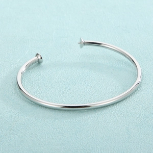Macro detail of silver stainless steel open DIY bracelet base with pearl mounting pins