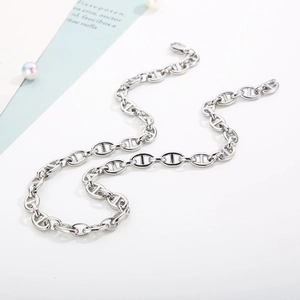 Detailed view of silver stainless steel anchor chain necklace with pearl accents