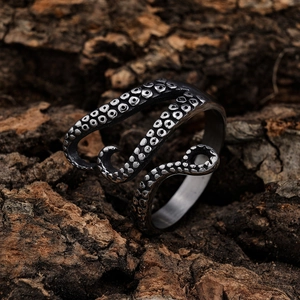 Gothic octopus tentacle ring in vintage silver stainless steel on dark wood background