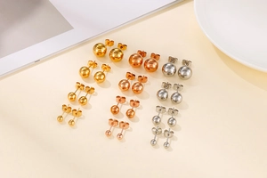 Close-up of assorted stainless steel ball stud earrings in gold, silver, and rose gold