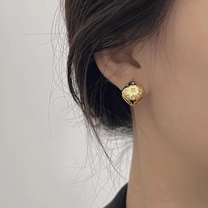 Detailed close-up of a gold square hoop earring featuring star engraving and zircon inlay