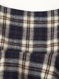 Close-up of classic navy and brown plaid fabric texture with woven details on casual top