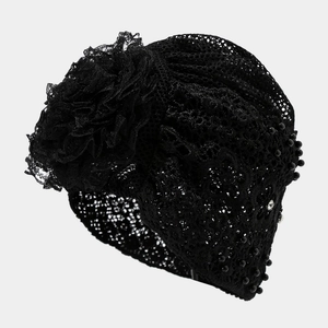 Detail von elegantem schwarzem Spitzen-Turban mit Blumendekor und Perlenbesatz