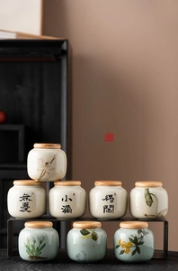 Close-up of hand-painted ceramic tea canisters with Chinese calligraphy and bamboo lids