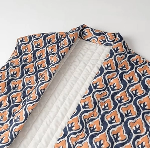 Detailed view of quilted vest neckline with orange blue and white geometric patterns