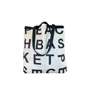 Off-white canvas tote bag with black letter print and dual strap handles