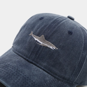 Detailaufnahme der Hai-Stickerei auf einer gewaschenen blauen Vintage-Baseballkappe