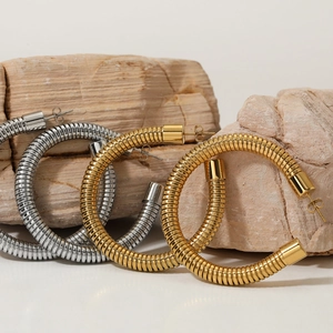 Textured C-shaped hoop earrings in gold and silver finish on natural stones