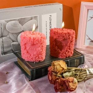 Close-up of heart love relief rose scented candle on vintage books for romantic decor