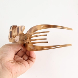 Detail of leopard print hair claw clip showing a durable spring and tortoise finish