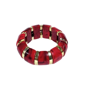 Détail d'un bracelet élastique avec blocs de résine marbrée rouge et séparateurs dorés