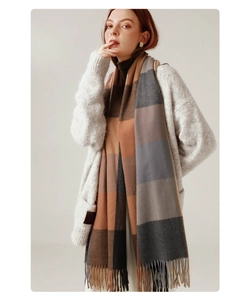 Detailed macro view of plaid wool blend scarf with fringe edges in brown and grey tones