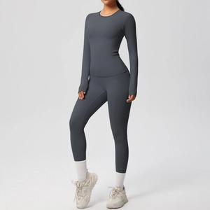 Dettaglio del set yoga grigio scuro con maglia a maniche lunghe e leggings aderenti