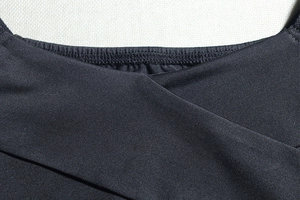 Detail of cross neckline and elastic knitted texture on this slim black bodycon dress