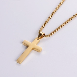 Polished golden stainless steel cross pendant with a box chain on white background
