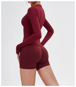 Detailansicht des nahtlosen dunkelroten Langarm-Crop-Tops und der engen Gym-Shorts