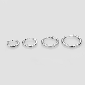 Macro shot of four pairs of solid S925 sterling silver hoop earrings in varying sizes