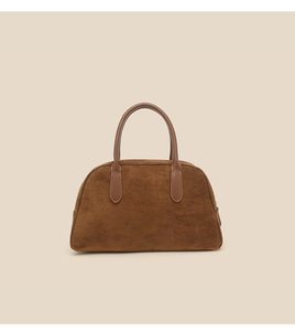 Detailed view of brown faux suede texture and smooth leather handle on a bowling bag