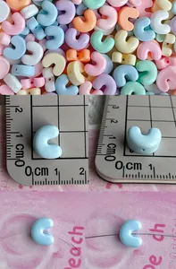 Macro detail of mixed macaron color resin C-shaped alphabet beads for DIY jewelry making