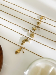 Detailed view of gold ocean-themed necklaces with seahorse and seashell pendants