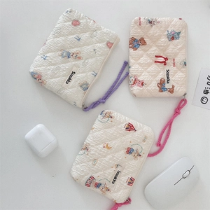 Close-up of floral quilted mini bags with bear and rabbit patterns and colorful lanyards