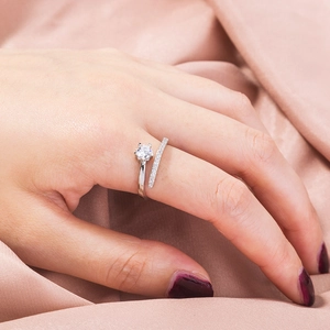 Detailed view of an open silver ring featuring a large zircon and parallel pavé diamonds
