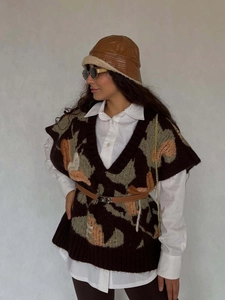 Chic brown patterned knit vest paired with a white shirt and stylish brown leather hat