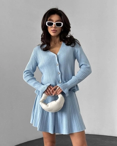 Détails de l'ensemble en tricot bleu clair avec boutons perlés et jupe plissée