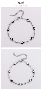 Detail view of colorful Hamsa Hand and Evil Eye charms on stainless steel bead bracelets