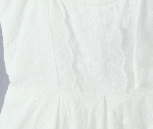 Vue macro de dentelle blanche délicate et de broderies florales sur la robe française
