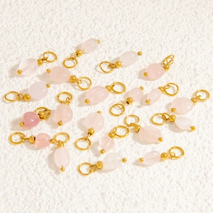 Close-up of pink oval quartz pendants with gold-plated metal loops for DIY jewelry