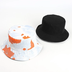 Detail view of tie-dye and plain black bucket hats with stitched reinforced brims