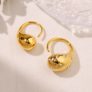 Detail of 18K gold plated teardrop ring with sparkling cubic zirconia on a warm background