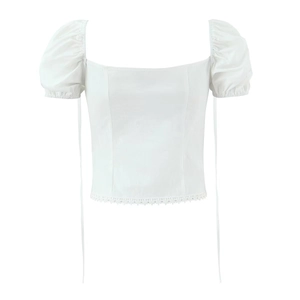 Détail du haut à manches bouffantes blanc avec col carré et broderie en dentelle
