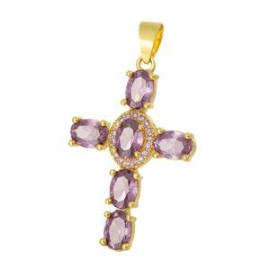 Detail of cross pendant with gold metal and large oval purple zircons on white backdrop